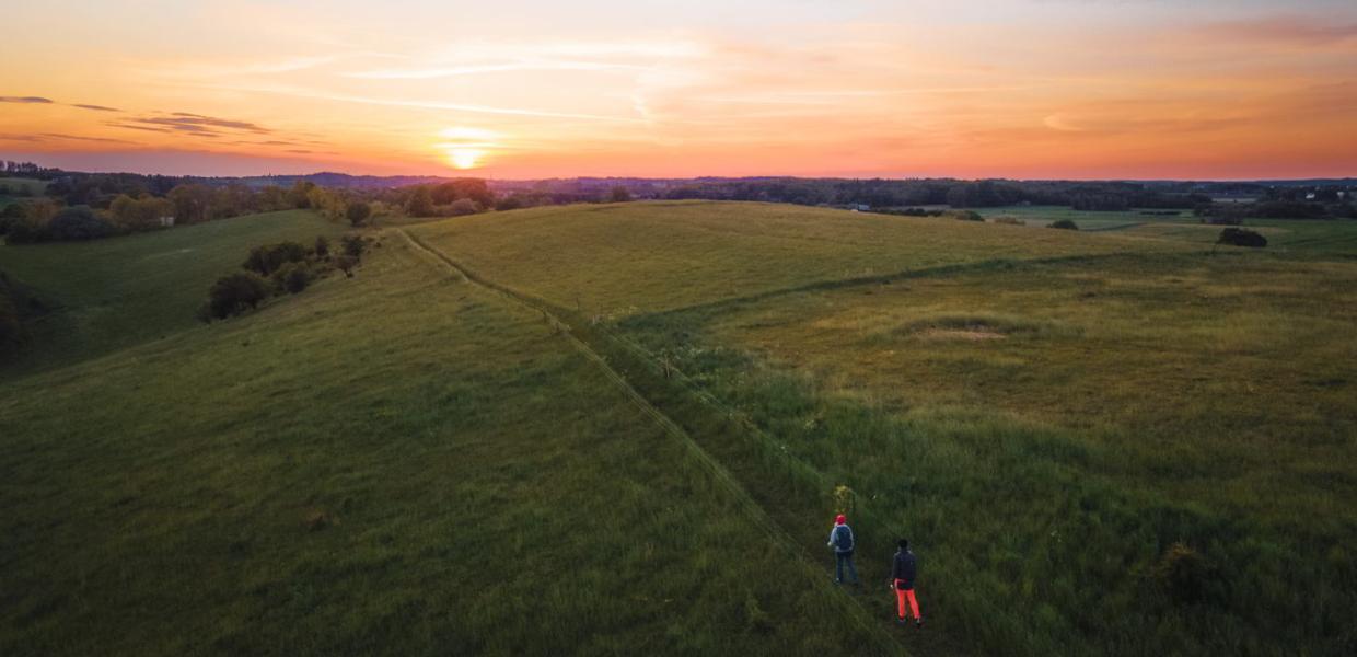 En drone filmer to vandrere på en eng på Halsninoen i Nordsjælland